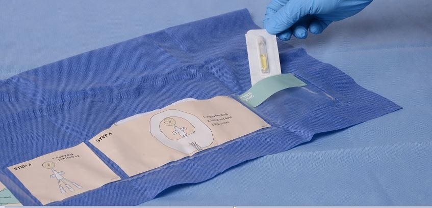 Dressing Securement Kit with hand placing Mastisol Liquid Adhesive Vial in kit